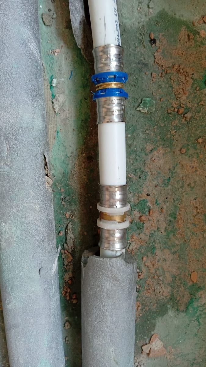 Wasserleitung an einer feuchten, alten Kellerwand