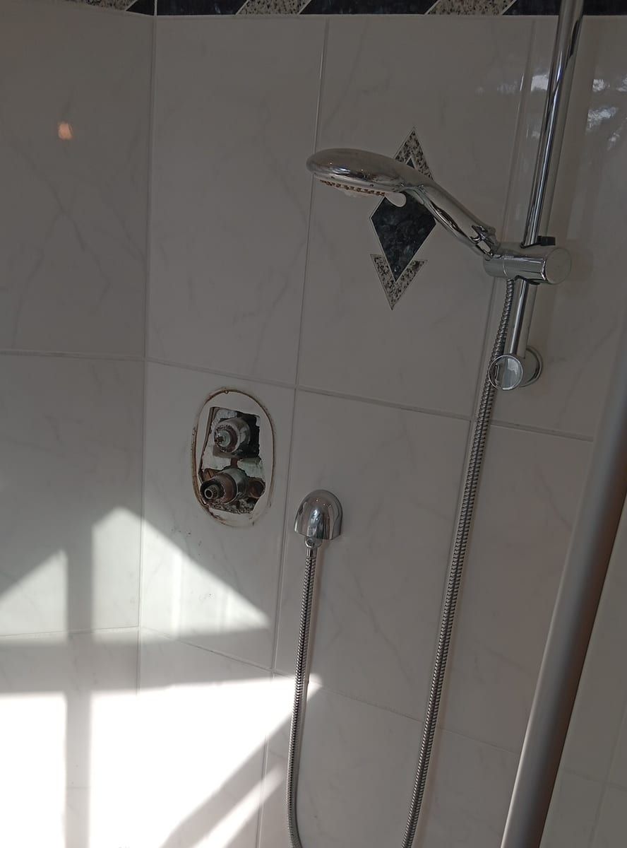 Dusche mit geöffneter Wand an den Anschlüssen
